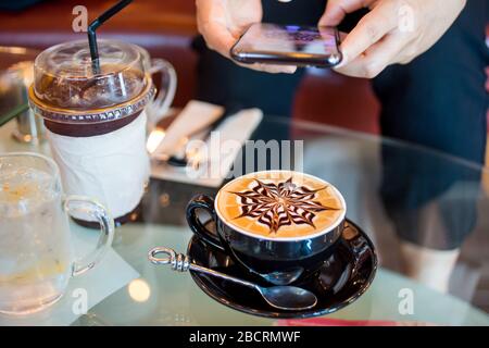 Close up of Latte coffee in grass cup on table Stock Photo