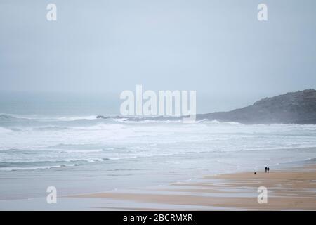 Lonely walkers on Fistral beach, Newquay, Cornwall Stock Photo