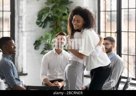 African American and caucasian women embracing at group therapy session. Stock Photo
