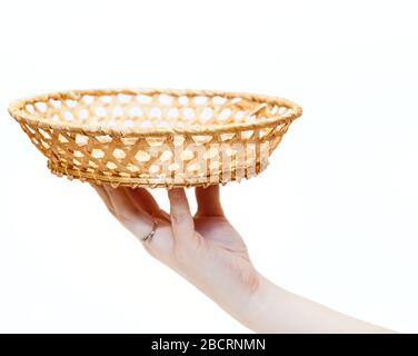 Wicker plate made from birch bark in human hand, isolated on a white background Stock Photo