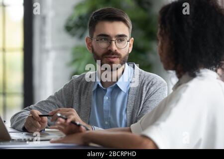Close up focused businessman talking with african american businesswoman. Stock Photo