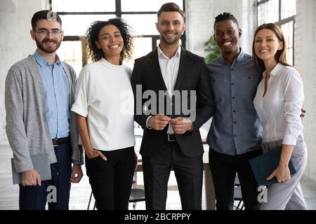 Standing in row smiling diverse team looking at camera. Stock Photo