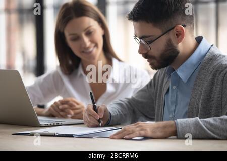 Close up handsome businessman signing partnership agreement concept.