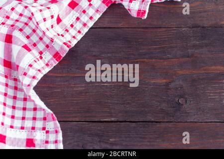 A red checked towel on an old wooden table. Stock Photo