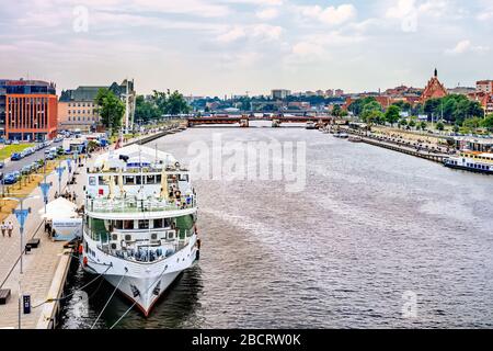 Szczecin Poland June 2018 Piastowski Boulevard on Odra River embankment with ships converted to restaurants. People walking and relaxing on river bank Stock Photo