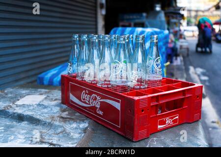 Box with empty glass bottles of Coca Cola, and other drinks. Recycling Glass Bottles. Stock Photo