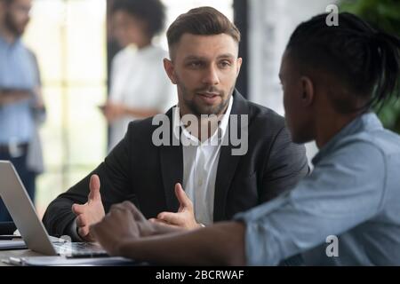 Close up confident businessman talking with african american businessman. Stock Photo