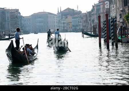 Rowing in the canals of Venice. Gondola tourists on the grand canal; an experience to do absolutely. Travel and tourism concept Stock Photo
