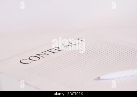 Contract paper and pen on white desk background. Focus on title Contract. Defocused pencil Stock Photo