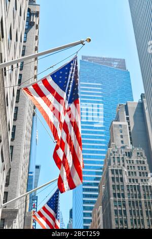 New York, USA - June 18, 2016: Americans flag on the building on one of New York street on Manhattan. Vertical photo Stock Photo