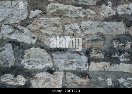 Ancient grey round stone wall flat background closeup Stock Photo
