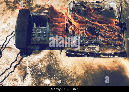 Fire in the office, burned phone and laptop Stock Photo