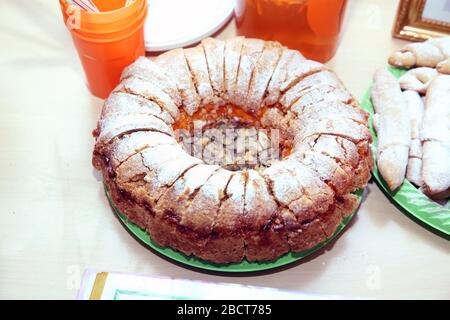 A rustic dessert that can be easily prepared at home. Top view of a round manna pie in a clay brown plate on a gray neutral background. Stock Photo
