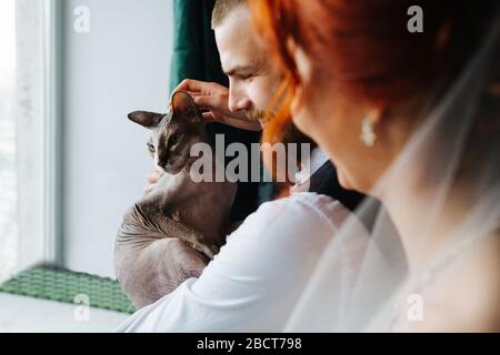 New family. Husband, wife and their hairless sphynx cat Stock Photo