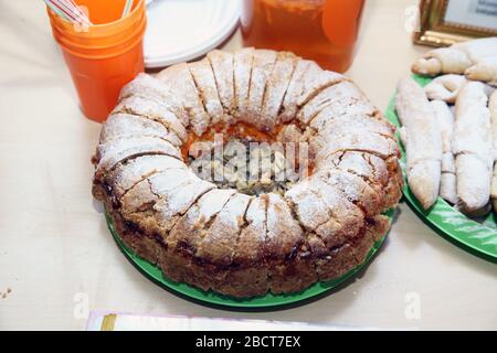 A rustic dessert that can be easily prepared at home. Top view of a round manna pie in a clay brown plate on a gray neutral background. Stock Photo