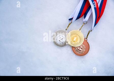 Gold silver and bronze medal, white snow background. Winter sport trophy for ski, hockey, nordic ski. Picture for winter game in pyeongchang 2018 Stock Photo