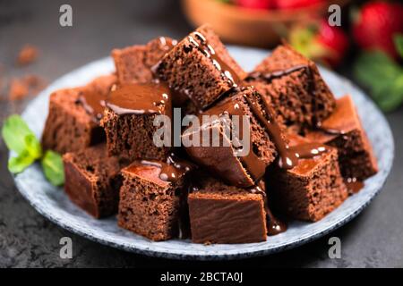 Chocolate brownie squares decorated with melted dark chocolate. Homemade chocolate cake, sponge cake Stock Photo