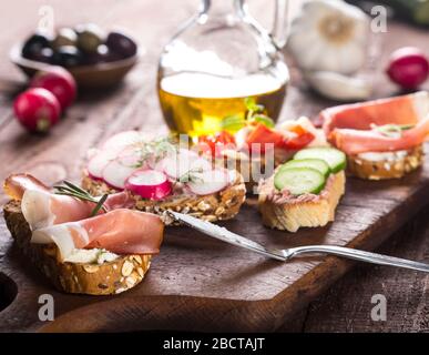 Set of different bruschettas on dark wooden table. Stock Photo