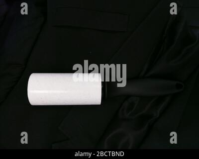Dust remover tool with reusable sticker cleaning black fabric suit Stock Photo