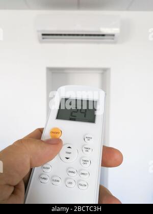 Male hand close up of adjusting temperature on air conditioning system Stock Photo