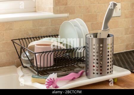 a close up view of clean dishing place in the drying rack in a open plan kitchen Stock Photo