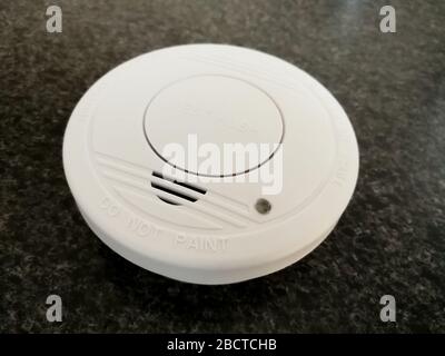 Plastic smoke alarm sensor isolated on the dark background Stock Photo