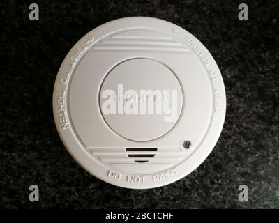 Plastic smoke alarm sensor isolated on the dark background Stock Photo