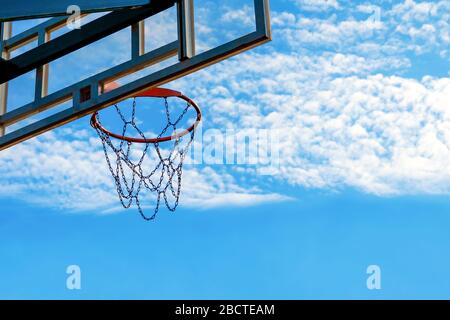 outdoor basketball game concept. basketball net against the blue sky with clouds. background Stock Photo