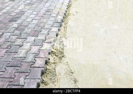 laying new pavement in the square, road, sidewalk. gray paving slabs in the sand Stock Photo