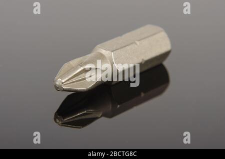 Professional mechanical screwdriver bit close up on the dark reflective background Stock Photo