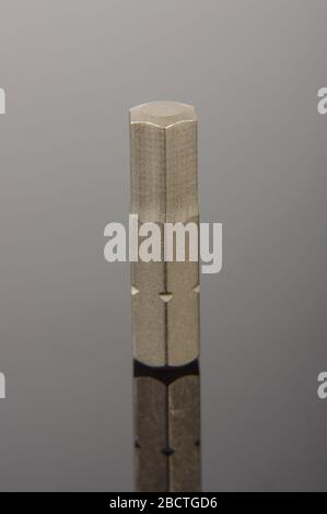 Professional mechanical screwdriver bit close up on the dark reflective background Stock Photo