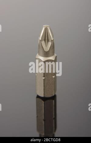 Professional mechanical screwdriver bit close up on the dark reflective background Stock Photo