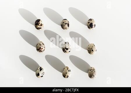Quail eggs on white table background. Unusual and different photo for easter. Beautiful sun light. Paschal concept. Stock Photo