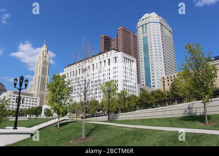 Alexander park Downtown Columbus Ohio green landscape with green trees, concrete walk way , colorful trees city skyline structure ,blue sky Stock Photo