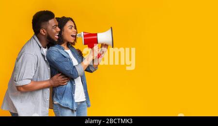 Joyful African American Couple Making Announcement Using Loudspeaker, Panorama Stock Photo