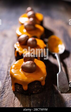 Easter muffins covered with orange icing.Chocolate dessert.Delicious food and drink Stock Photo