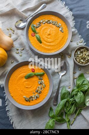 Pumpkin soup and organic pumpkins on kitchen table Stock Photo