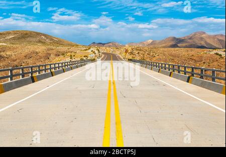 On the road on a highway connecting the Andes mountains of Bolivia with the Uyuni Salt Flat, South America. Stock Photo