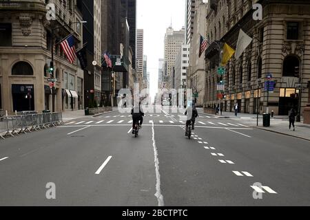 New York City, USA. 05th Apr, 2020. Two men ride their bikes down an empty seciton of 5th Avenue, as New Yorkers are asked to stay at home and non-essential businesses remain close due to the Coronavirus pandemic, New York, NY, April 5, 2020. New York Gov. Andrew Cuomo announced the first drop in the number of deaths due to COVID-19 infection in New York State without giving the reason. (Anthony Behar/Sipa USA) Credit: Sipa USA/Alamy Live News Stock Photo