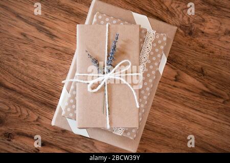 Three vintage style gift wrapped books in a stack on a wooden surface. Stock Photo