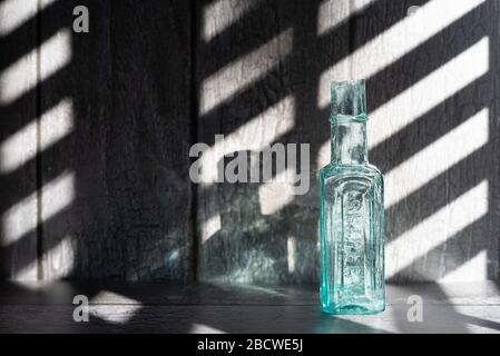 Vintage blue glass bottles with abstract graphic shadow - still life Stock Photo