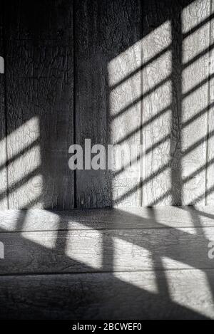 Graphic abstract shadow lines on dark wooden surface. Stock Photo