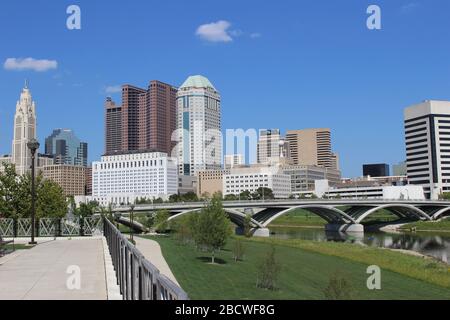 Alexander park Downtown Columbus Ohio green landscape with green trees, concrete walk way , colorful trees city skyline structure ,blue sky Stock Photo