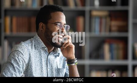 Smiling african American man laugh talking on cellphone Stock Photo