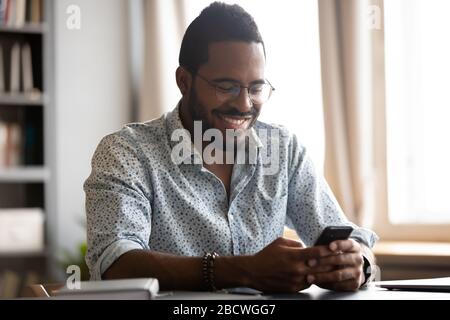 Smiling biracial man have fun using modern smartphone Stock Photo
