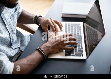 Top view of african american man texting on laptop keyboard Stock Photo