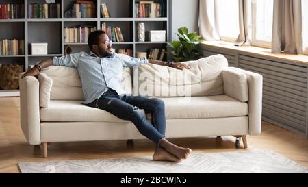 Relaxed biracial man rest on couch dreaming Stock Photo