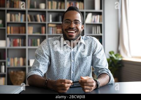 Headshot portrait of smiling biracial man having video call Stock Photo