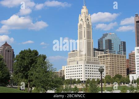 Alexander park Downtown Columbus Ohio green landscape with green trees, concrete walk way , colorful trees city skyline structure ,blue sky Stock Photo