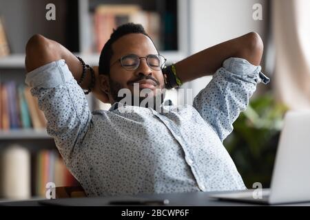Happy biracial male employee relax at workplace Stock Photo